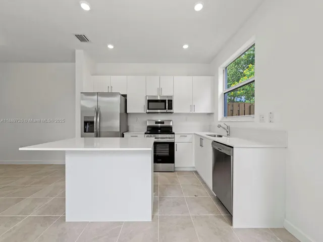 a kitchen with a stove a sink and a microwave