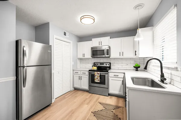 a kitchen with stainless steel appliances a refrigerator sink and microwave