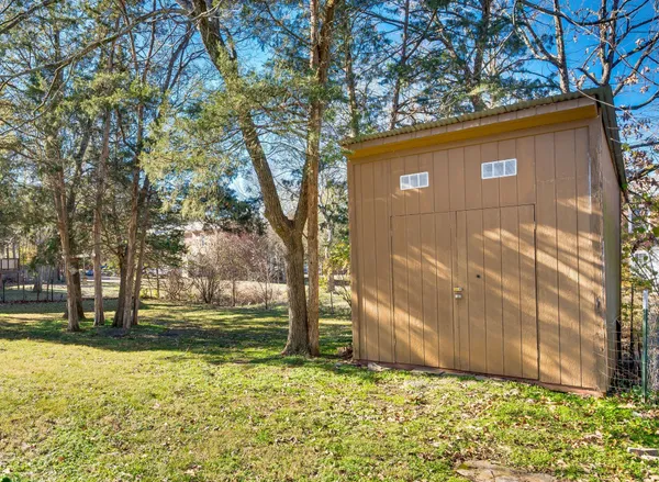 a view of a yard with wooden fence