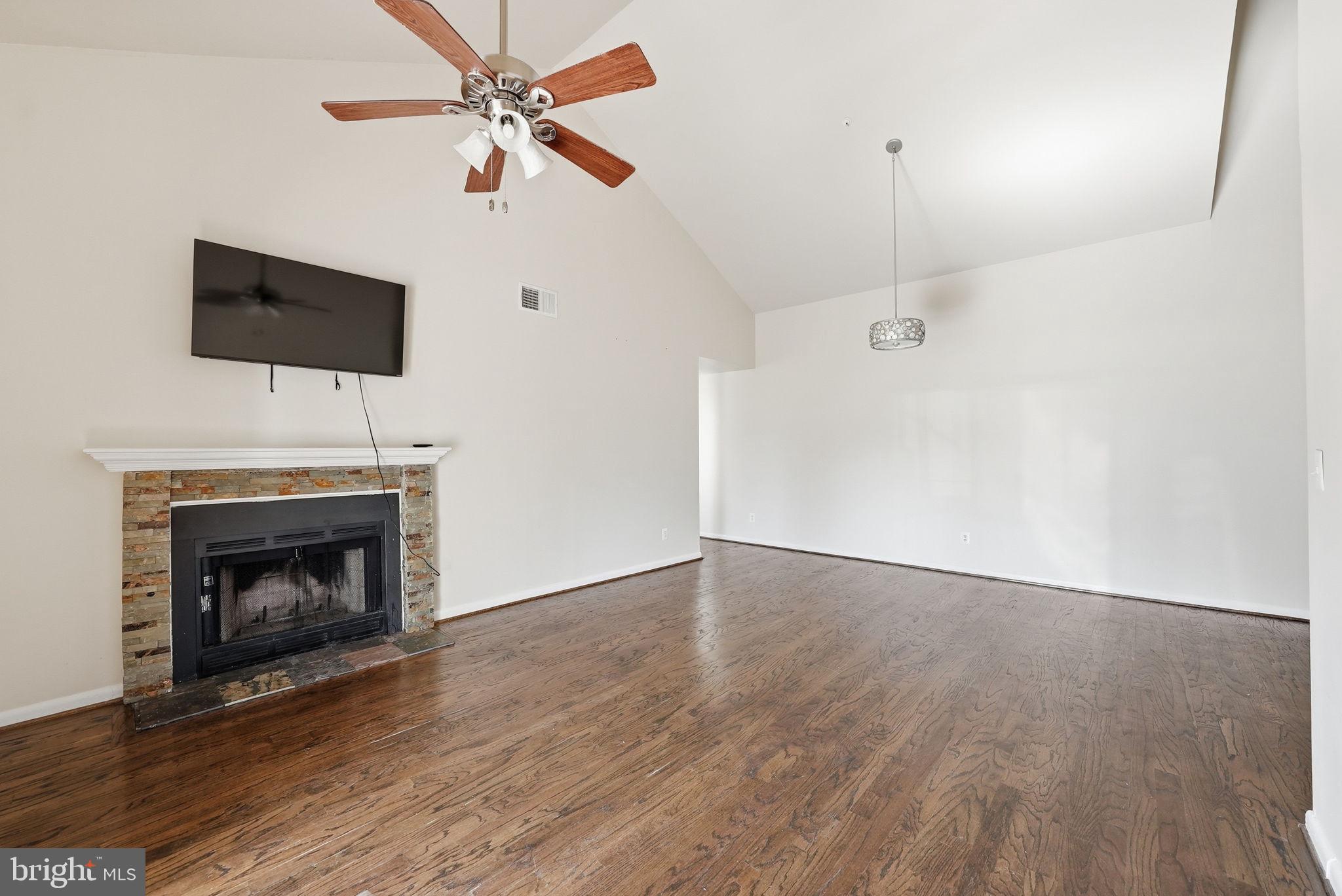 1003 Spring Valley Court Fort Washington, MD 20744 - Photo 6 of 25 a view of an empty room with wooden floor a fireplace and a window