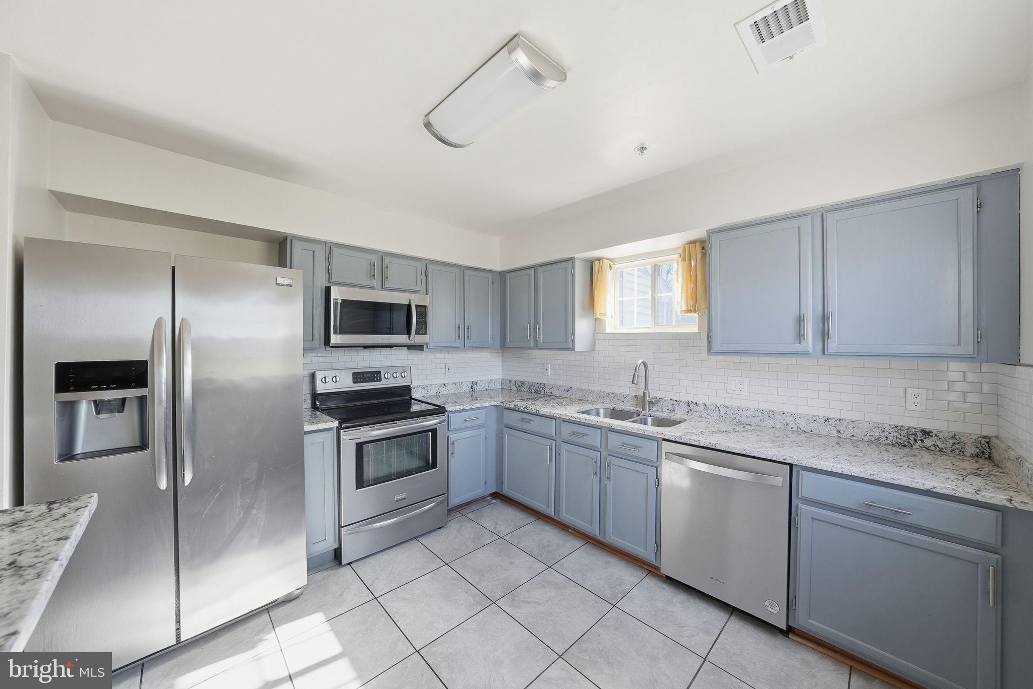 1003 Spring Valley Court Fort Washington, MD 20744 - Photo 7 of 25 a kitchen with a sink and stainless steel appliances