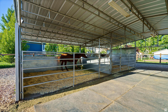 681 Island Road Morgan, UT 84050 - Photo 26 of 49 Metal-framed equestrian shelter featuring multiple partitioned stalls, a corrugated metal roof, and concrete flooring