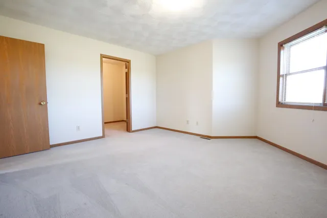 an empty room with windows and closet