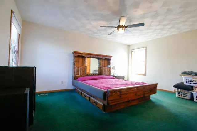 a spacious bedroom with a bed and a chandelier