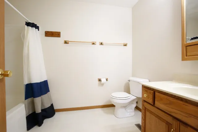 a white toilet sitting next to a bathroom sink and vanity