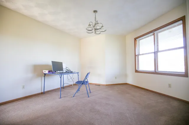 a view of a workspace with furniture and a window