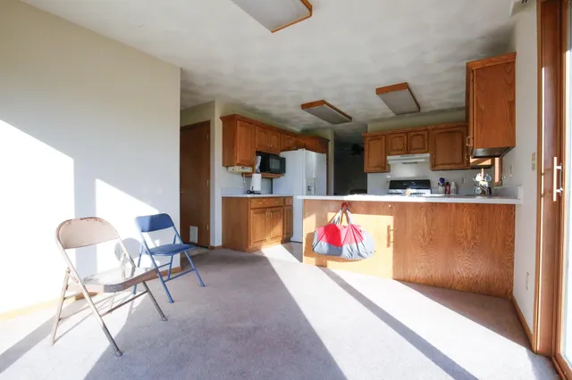 a living room with furniture kitchen appliances and a table