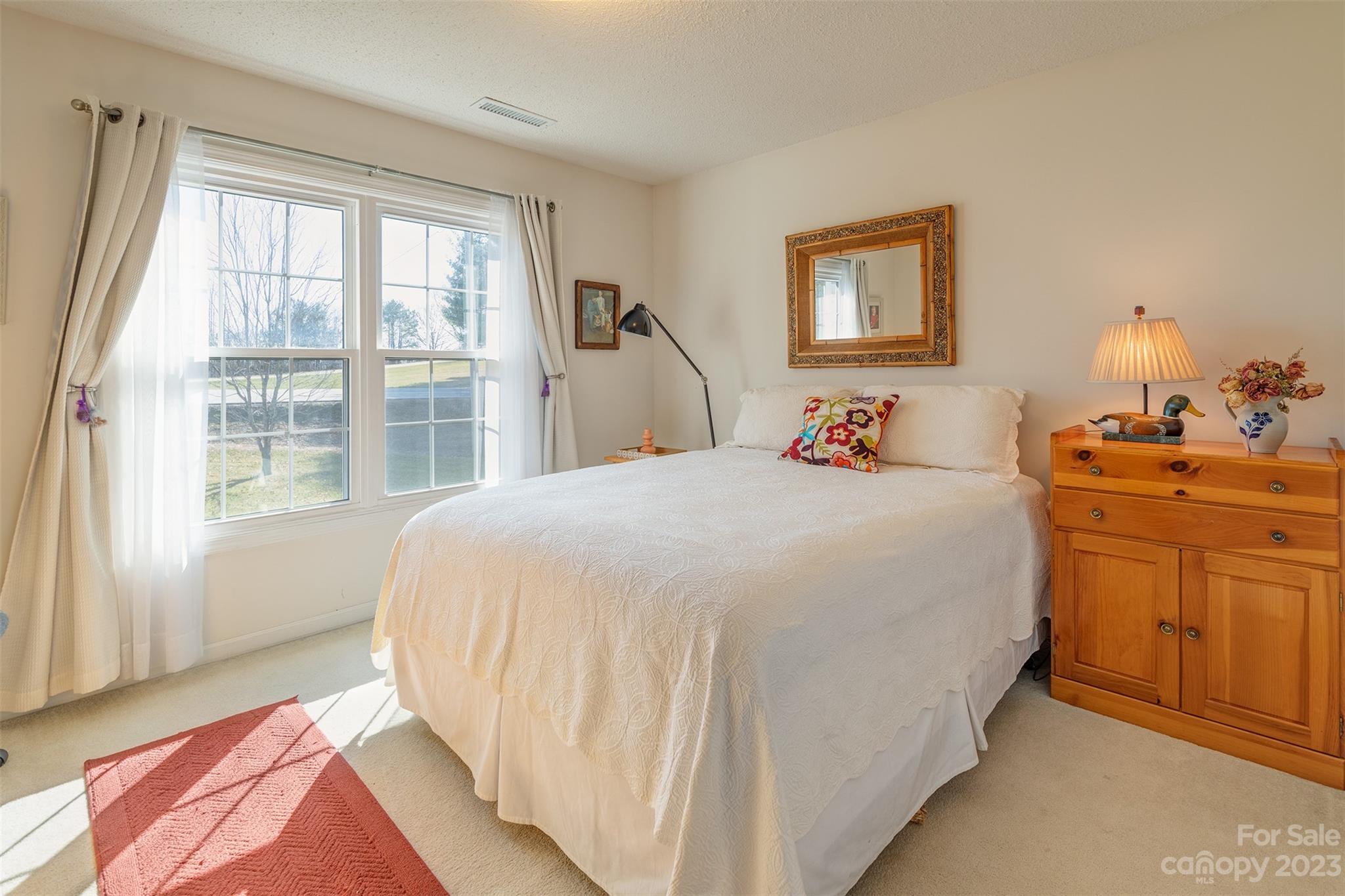 1315 Alexander Road Leicester, NC 28748 - Photo 18 of 28 a bedroom with a bed and a dresser next to a window