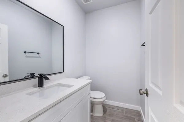 a bathroom with a sink a toilet and mirror