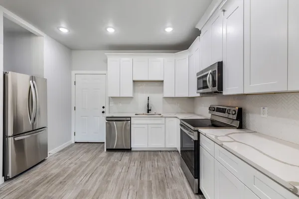 a kitchen with a refrigerator sink and cabinets