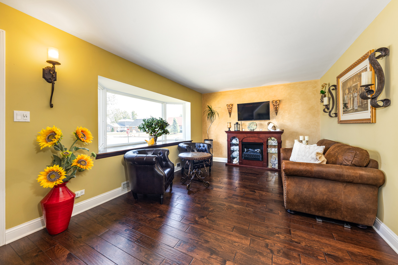 9236 Pembroke Lane Bridgeview, IL 60455 - Photo 12 of 40 a living room with furniture a fireplace and a flat screen tv