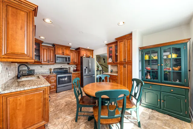 a kitchen with stainless steel appliances granite countertop a stove a sink dishwasher and cabinets with wooden floor