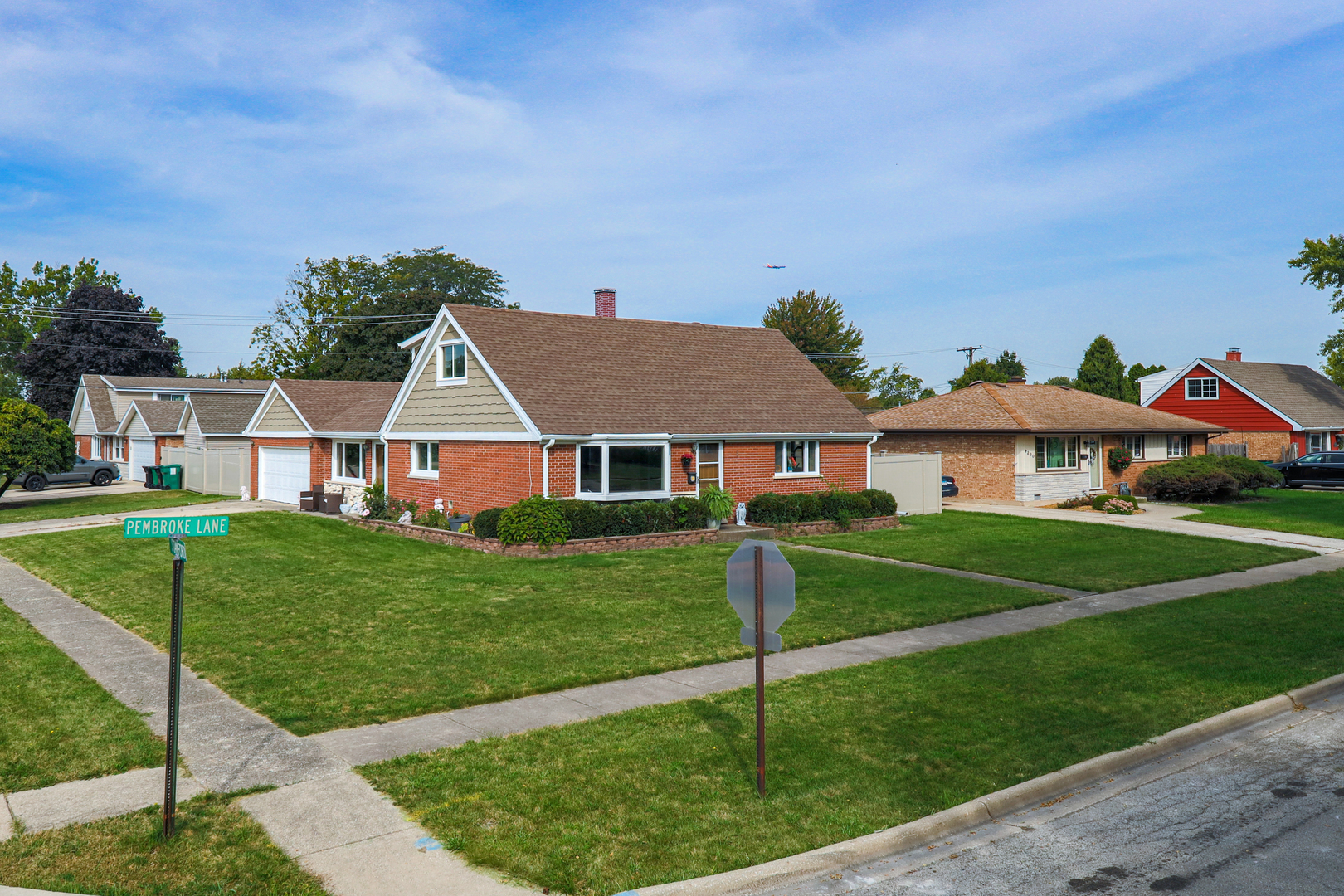 9236 Pembroke Lane Bridgeview, IL 60455 - Photo 5 of 40 a view of a white house next to a yard with big trees