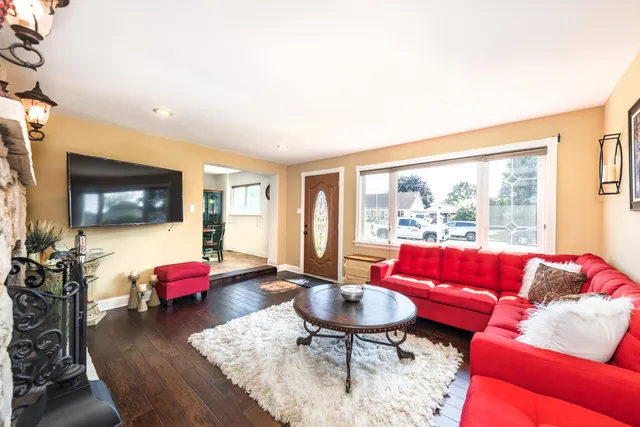 a living room with furniture a flat screen tv and a large window