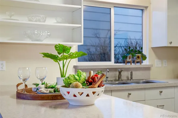 a white vase with flowers on a table