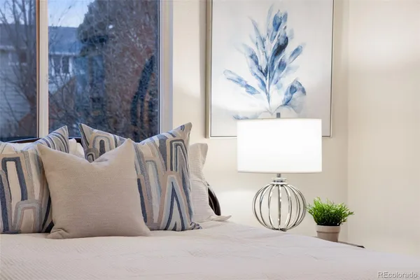 a bedroom with a bed and a painting on the wall