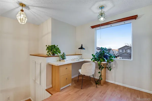 a dining room with furniture potted plants and wooden floor
