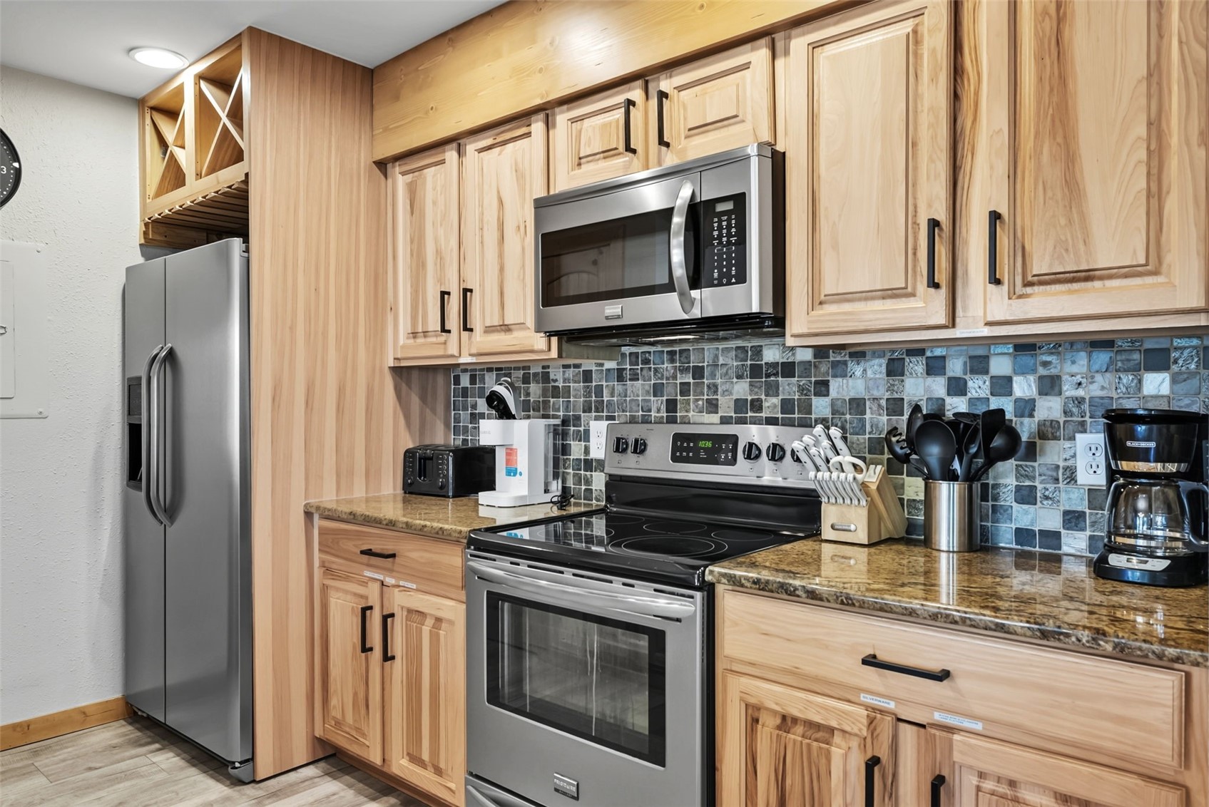 325 Four O Clock Road North, Unit B103 Breckenridge, CO 80424 - Photo 3 of 19 a kitchen with stainless steel appliances granite countertop a stove a microwave and a refrigerator