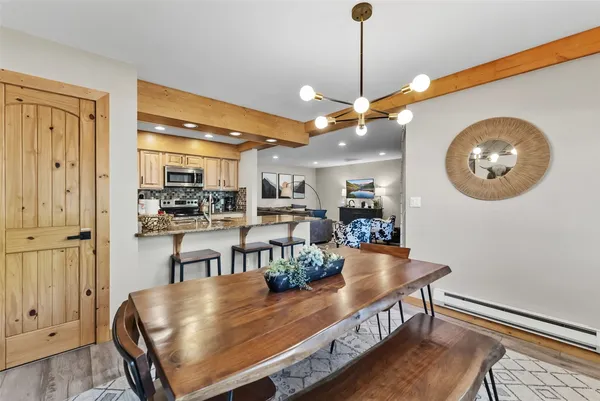 a living room with stainless steel appliances kitchen island granite countertop furniture and a ceiling fan