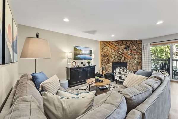 a living room with furniture a large window and a fireplace