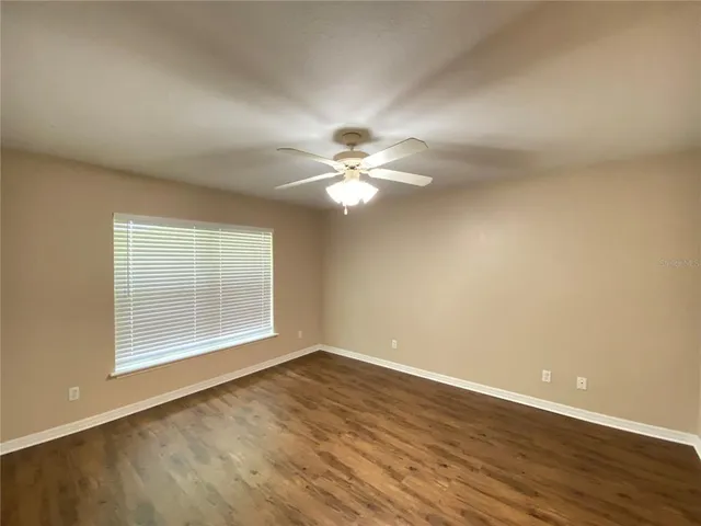 a view of a room with wooden floor and fan