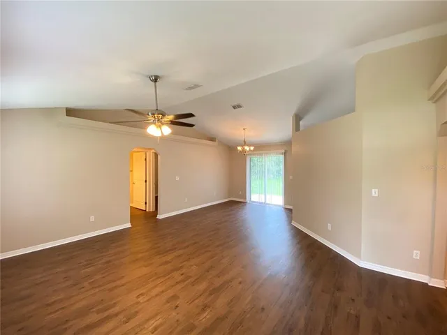 a view of a livingroom with a ceiling fan window and wooden floor