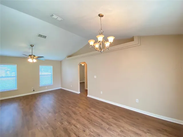 a view of a livingroom with a chandelier wooden floor chandelier and windows