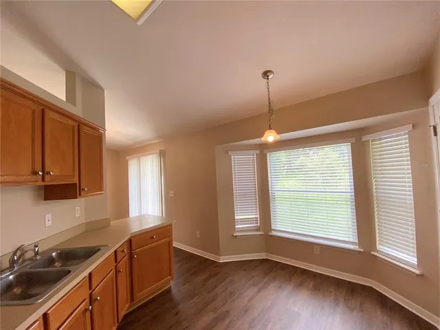 a kitchen with stainless steel appliances granite countertop wooden cabinets and a window