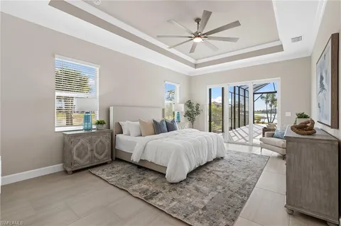 a spacious bedroom with a large bed and a chandelier