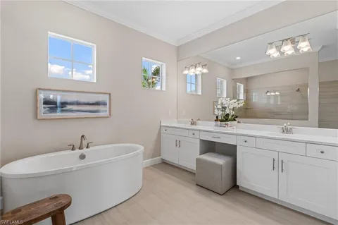 a spacious bathroom with a double vanity sink a mirror and a bathtub