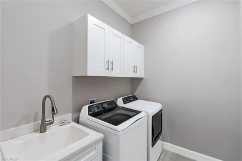 a utility room with sink dryer and washer