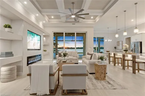 a living room with furniture a fireplace and a kitchen view