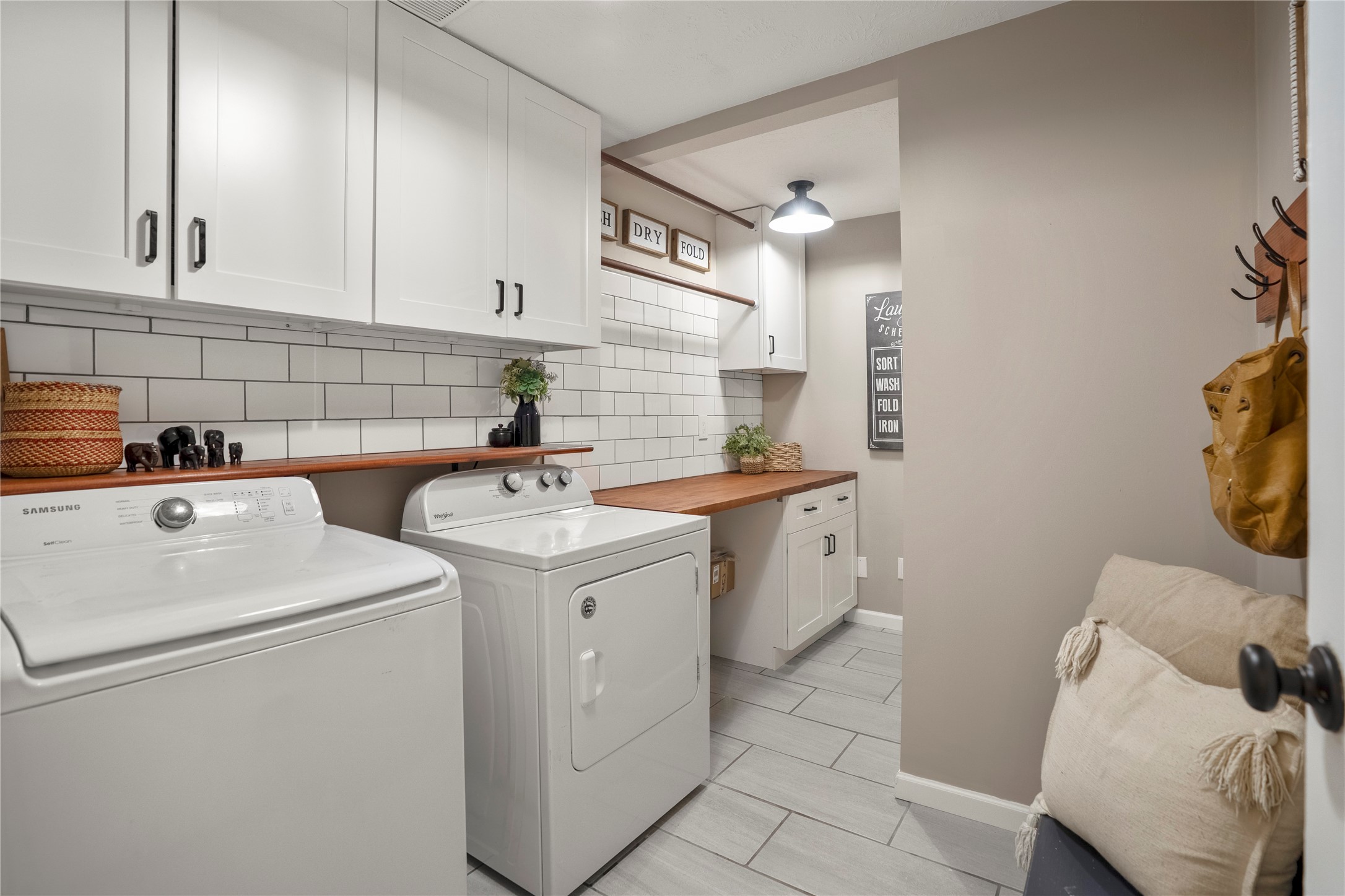 12224 Gun Oak Place Spring, TX 77380 - Photo 27 of 43 Updated laundry room featuring extended butcher block countertops, abundant storage, a built-in hanging rack, and a beautifully designed space with thoughtful attention to detail that brings both function and style.