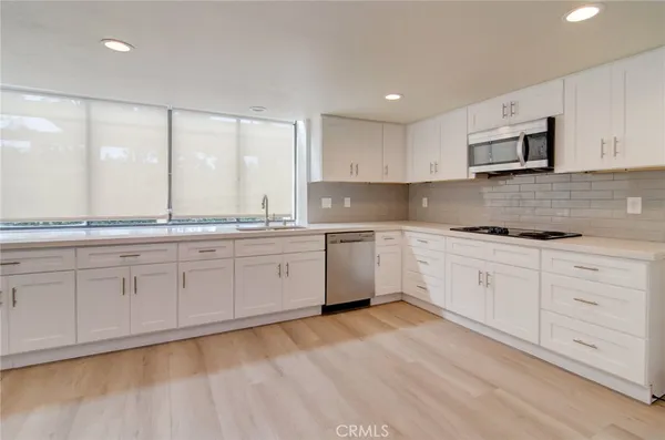 a kitchen with granite countertop white cabinets white stainless steel appliances with a sink and dishwasher