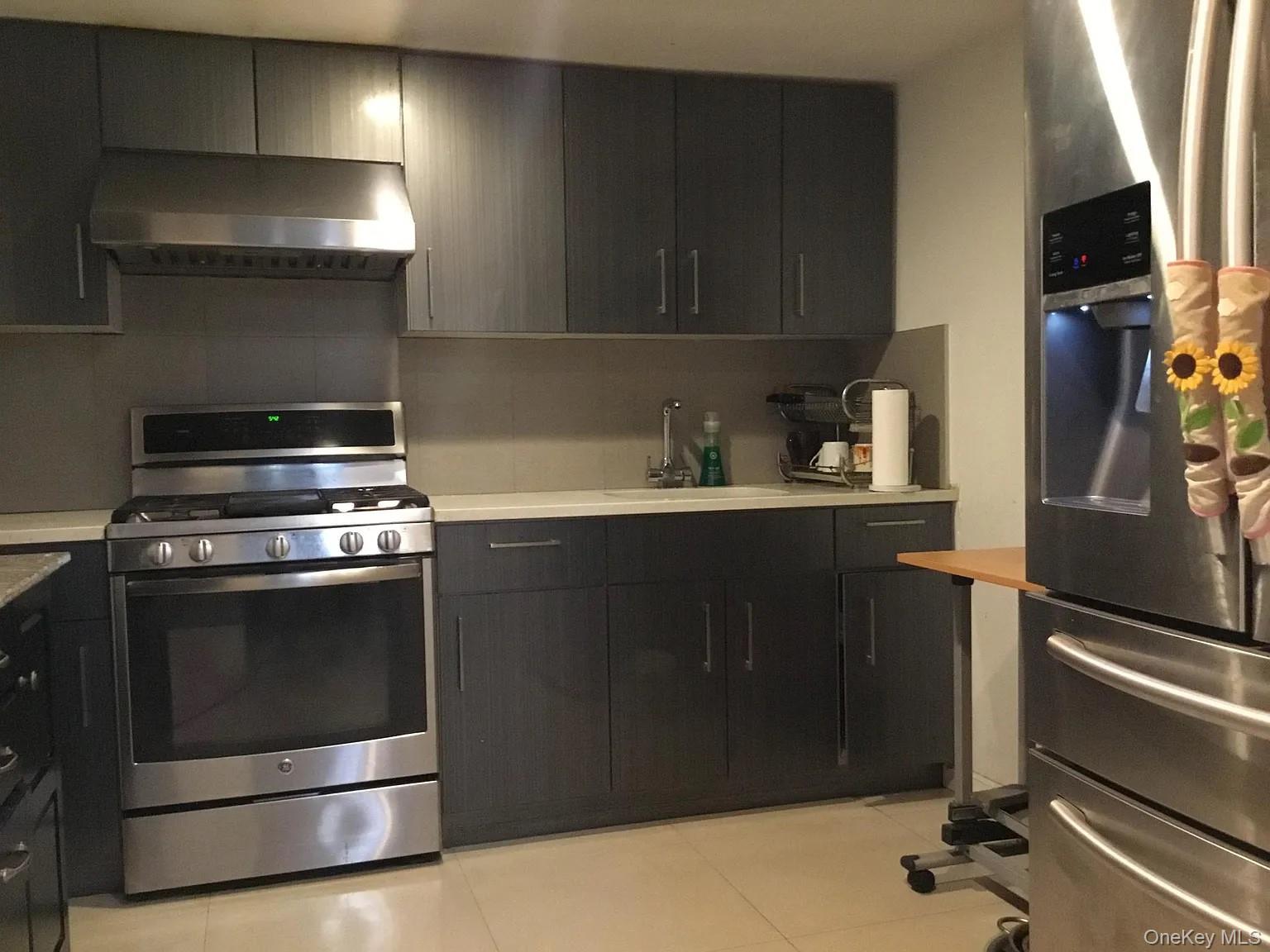 160-06 75th Road, Unit 3 Queens, NY 11366 - Photo 3 of 3 a kitchen with a stove and a microwave
