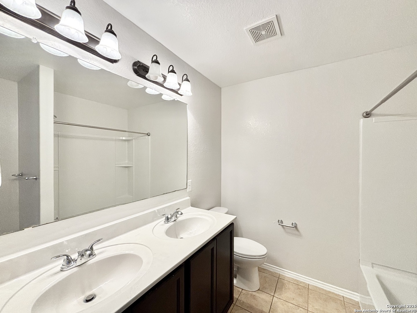 9358 Fisherman Converse, TX 78109 - Photo 14 of 22 a bathroom with a double vanity sink toilet and mirror