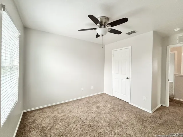 a view of a big room with wooden floor closet and windows in it
