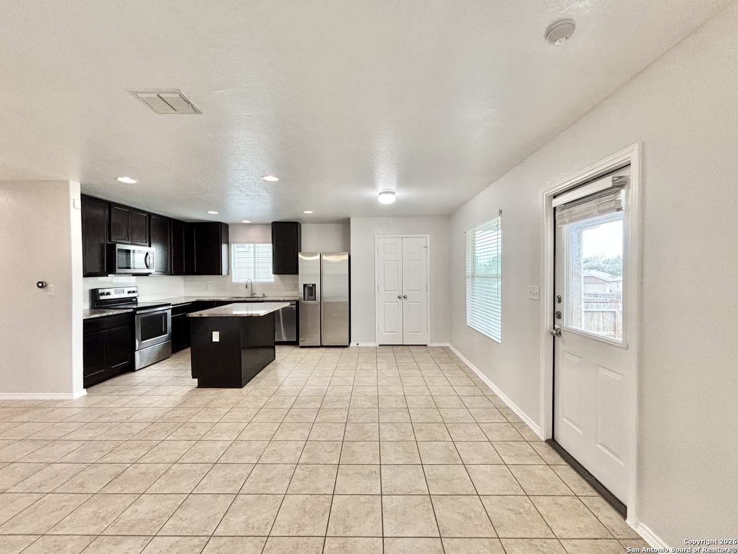 9358 Fisherman Converse, TX 78109 - Photo 3 of 22 a large white kitchen with a stove a sink dishwasher and a refrigerator with wooden floor