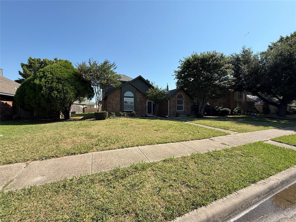 7913 Rice Drive Rowlett, TX 75088 - Photo 1 of 25 Brick exterior with dark trim and an arched window