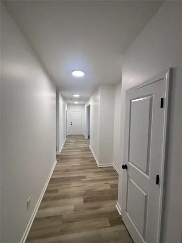 a view of a hallway with wooden floor and staircase