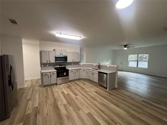 a kitchen with stainless steel appliances a refrigerator and a stove top oven
