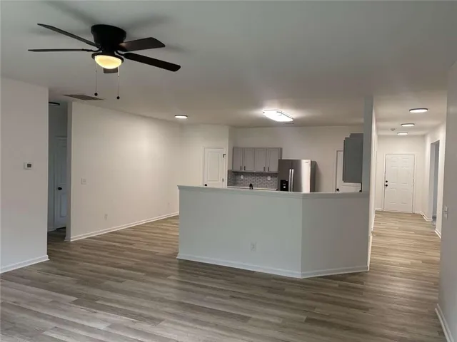 a living room with hard wood floors and a ceiling fan