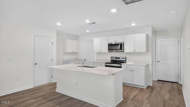 a kitchen with stainless steel appliances granite countertop a sink stove and wooden floor