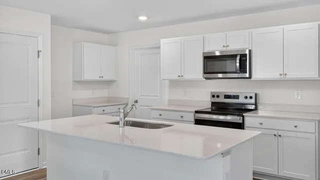 a kitchen with white cabinets a sink and white appliances