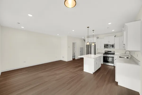a kitchen with a refrigerator and a stove top oven
