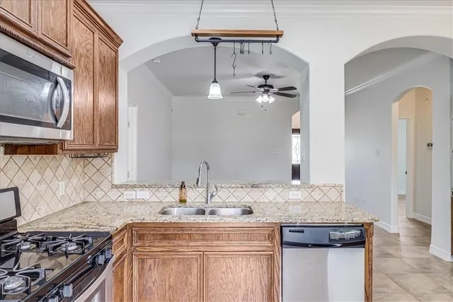 a kitchen with kitchen island granite countertop a sink stove and cabinets