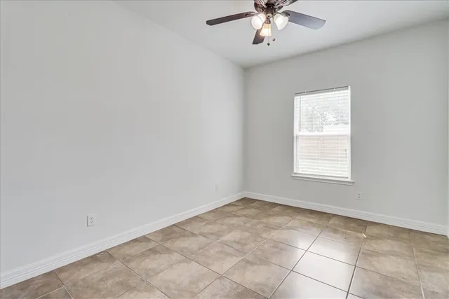 en empty room with windows and chandelier fan