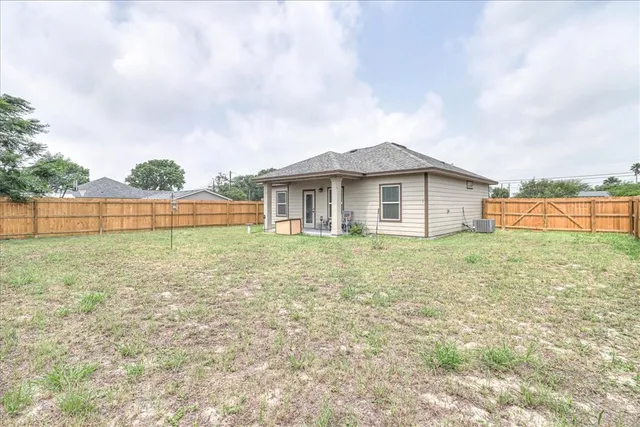 a view of a backyard with brick wall and wooden fence