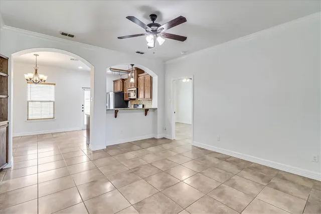 a view of a livingroom with a chandelier fan and kitchen