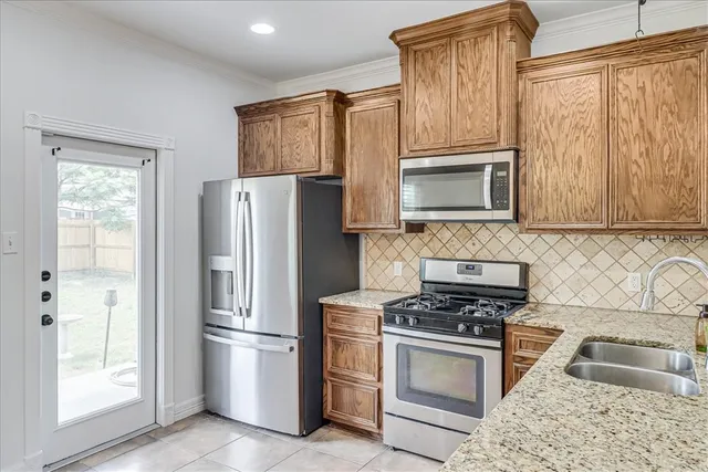 a kitchen with granite countertop a refrigerator stove and microwave
